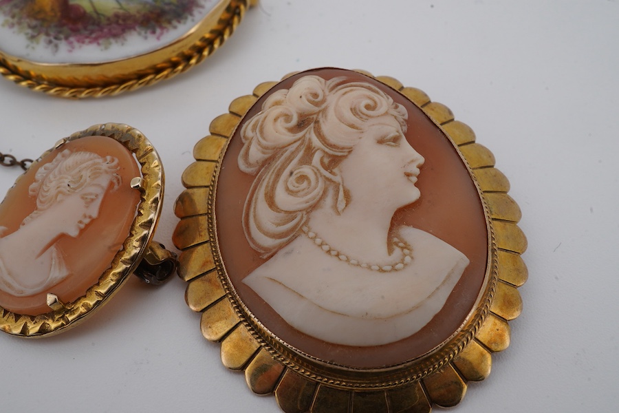 Three brooches, comprising: two shell cameo brooches, each mounted in 9ct gold, largest 4.5cm; and an enamel brooch depicting a pheasant, mounted in gold, length 3.7cm, stamped 9CT